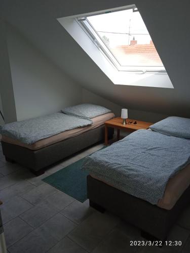 two beds in a bedroom with a skylight at Zimmer Frei 3 in Wiesbaden