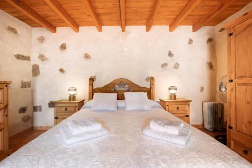 a bedroom with a large bed with two night stands at Casa Rural Andresito in Pájara