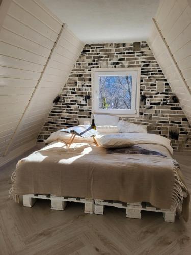 Bett in einem Zimmer mit Ziegelwand in der Unterkunft Jázminka alpesi házikó in Bükkszentkereszt