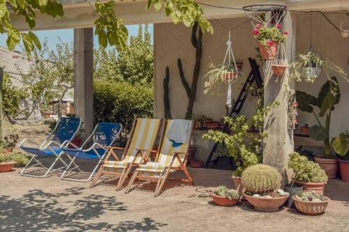 Villa delle Stelle في Cassaro: مجموعة من الكراسي والنباتات على الفناء