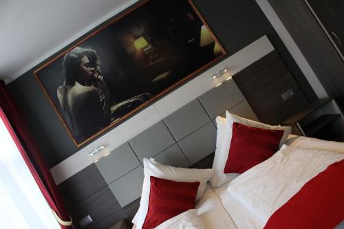 a bedroom with a bed with red and white pillows at Rheinhotel Lilie in Boppard