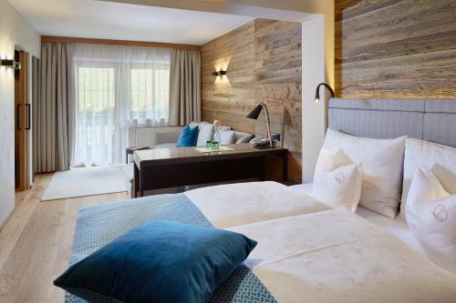 a hotel room with a bed and a desk at ZillergrundRock Luxury Mountain Resort in Mayrhofen