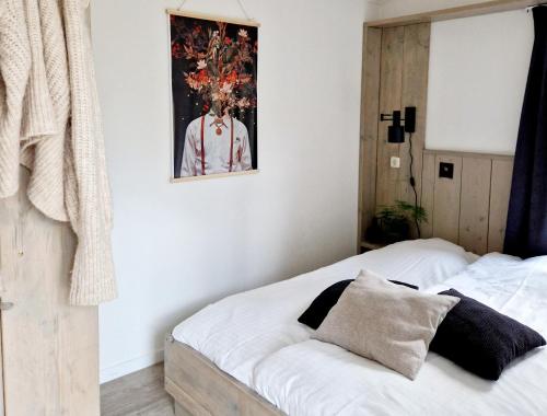 1 dormitorio con 2 camas y una foto en la pared en Lodge Koolmees Nunspeet Veluwe, en Nunspeet