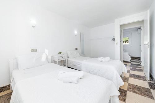 three white beds in a room with a checkered floor at Entire Large Villa next to Award-winning beach in Campoamor