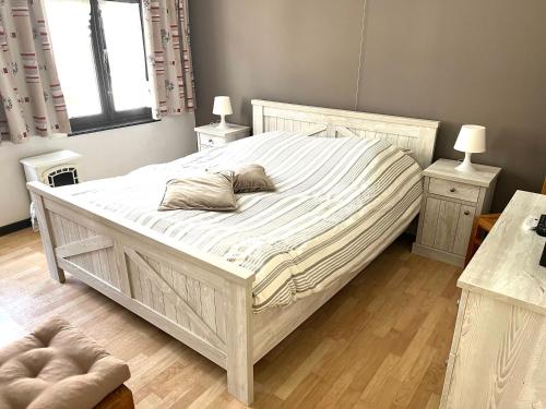 a bedroom with a large white bed with two tables at Chez’ Elle in Blankenberge