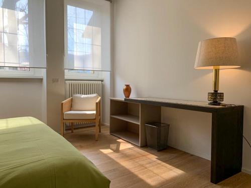 1 dormitorio con escritorio con lámpara y silla en Como Lake Crispi 7 Apartment, en Como