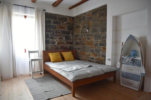 a bedroom with a bed and a brick wall at Villa Carla - Istrian house in Koper