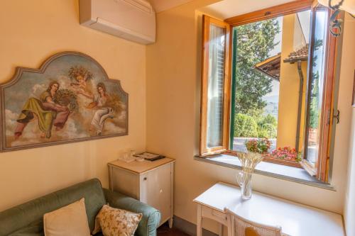 - un salon avec un canapé et une fenêtre dans l'établissement Agriturismo Vecchio Borgo Di Inalbi, à Impruneta