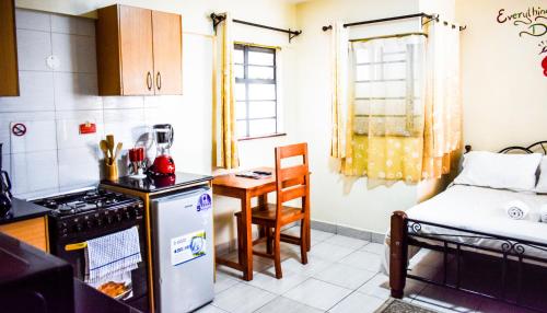 Affordable furnished apartments at the city centre في نيروبي: مطبخ صغير فيه طاولة وسرير