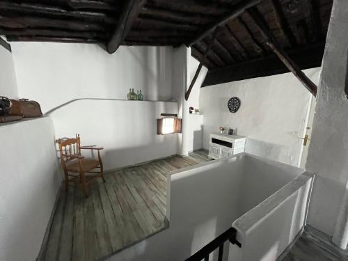 um quarto branco com uma mesa e uma banheira em Casa Rural Las Raíces, Sierra de San Vicente em San Román