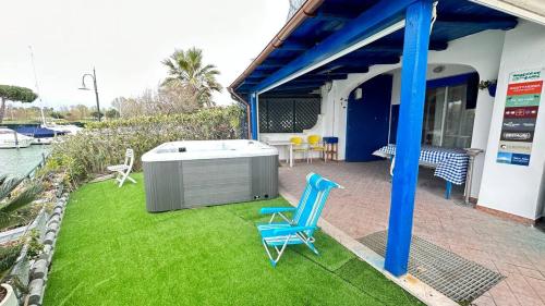 a patio with a hot tub and a blue chair at CA' DEI GELSI BEACH in Misano Adriatico