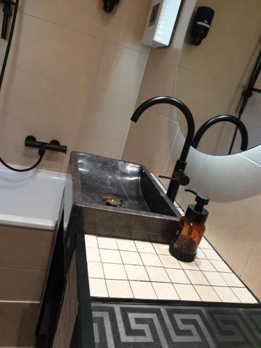 un lavandino in bagno con dispenser di sapone su un bancone di Miet-Kamp ruhig, zentral, nahe Messe, ausgefallenes design 2 Schlafzimmer a Berlino