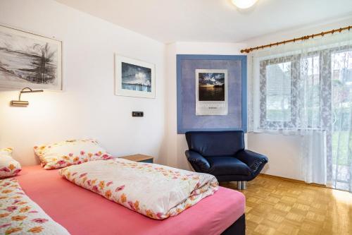 a bedroom with a bed and a chair at Sonnenstube in Langenargen