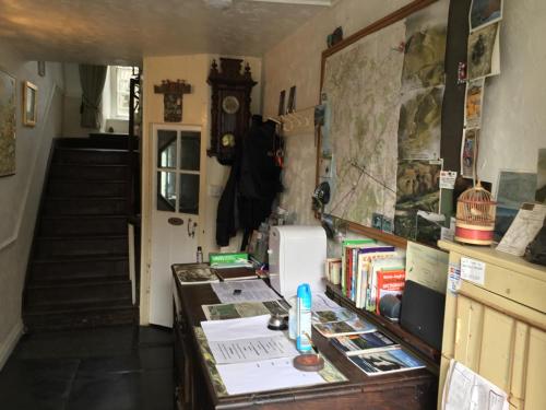 een kamer met een bureau met boeken en een klok bij Ty Seren in Dolgellau