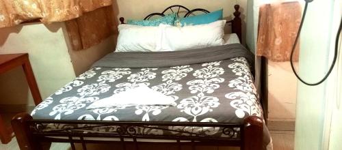a small bed with a black and white comforter and pillows at Affordable furnished apartments at the city centre in Nairobi