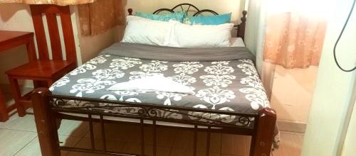 a small bed with a black and white comforter at Affordable furnished apartments at the city centre in Nairobi
