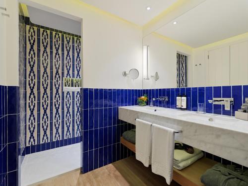 a bathroom with two sinks and blue and white tiles at H10 Atlantic Sunset Horizons Collection in Adeje