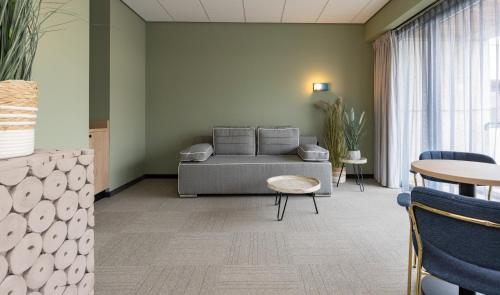 a living room with a couch and a table at Fletcher Hotel-Restaurant Marknesse in Marknesse