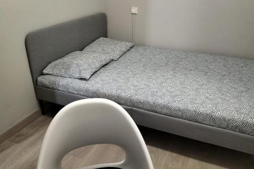 ein Bett in einem Zimmer mit einem Stuhl daneben in der Unterkunft VibesCoruña- San Rosendo 25 in A Coruña
