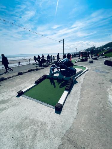 a group of people sitting on a bench near the beach at Boardwalk@TheBay, Filey in Filey