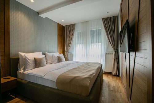 a bedroom with a large bed with a window at MM Central luxury in Kolašin