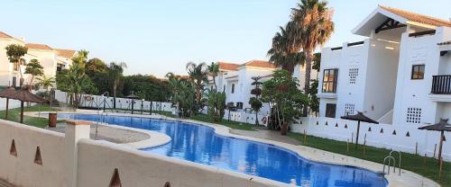 a swimming pool in front of some buildings at La Alcaidesa Valerie & Bruno in San Roque
