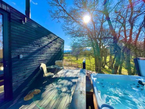 a hot tub on the deck of a house at The Roost in Aviemore