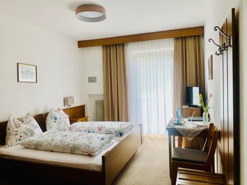Tannerhof Bed & Breakfast في Caines: غرفة نوم بسرير وطاولة ونافذة
