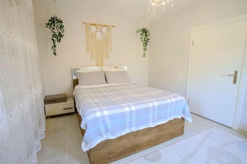 1 dormitorio con 1 cama con manta azul y blanca en Villa Olive Garden House, en Fethiye