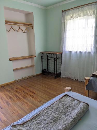 a bedroom with a bed and a wooden floor at Tatev Guest House in Tatʼev