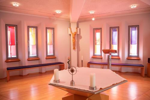 a room with windows and a table with candles at Spectrum Kirche Exerzitien-und Bildungshaus auf Mariahilf in Passau