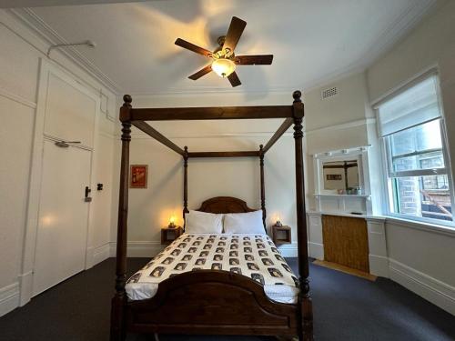 a bedroom with a canopy bed with a ceiling fan at The Resch House in Sydney