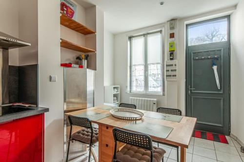 eine Küche mit einem Tisch, Stühlen und einer grünen Tür in der Unterkunft Lovely city house in the heart of Honfleur - Welkeys in Honfleur