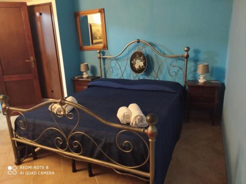 una camera da letto con un letto blu e asciugamani di Turismo Egadi - Villette a Favignana