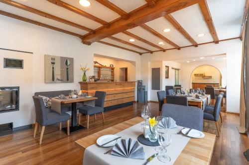 a dining room with tables and chairs and a fireplace at Hotel- Weingut- Moselloreley in Piesport