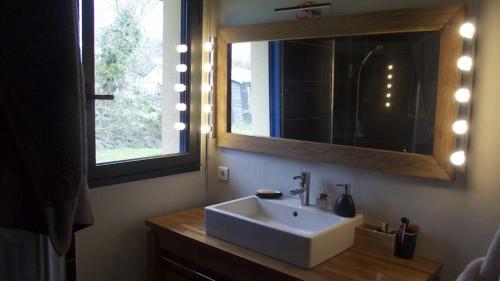 baño con lavabo, espejo y ventana en maison de plain pied a 1 km de la mer , avec piscine securisée, en Fouesnant