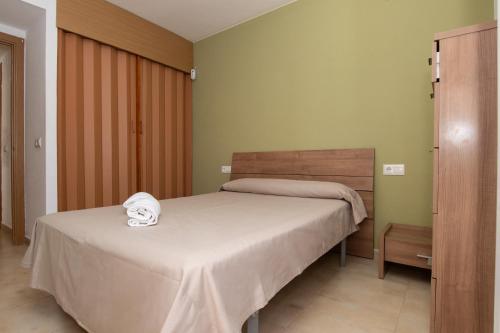 Un dormitorio con una cama con una toalla encima. en Rentalmar Mar i Cel, en Miami Platja