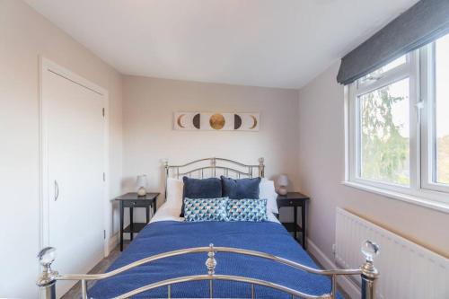 a bedroom with a bed with blue pillows and a window at PRIME SPOT FOR ASCOT & WINDSOR - 2 BEDROOMS in Ascot