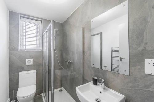 y baño con aseo, lavabo y espejo. en PRIME SPOT FOR ASCOT & WINDSOR - 2 BEDROOMS en Ascot