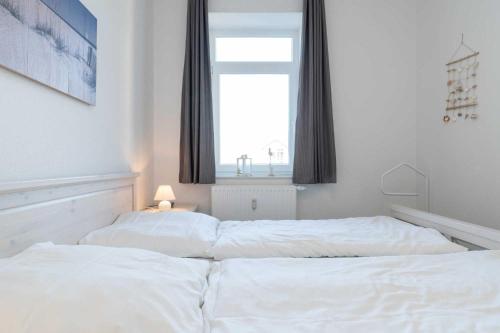 2 witte bedden in een slaapkamer met een raam bij Villa Marin Wohnung 16 in Zinnowitz