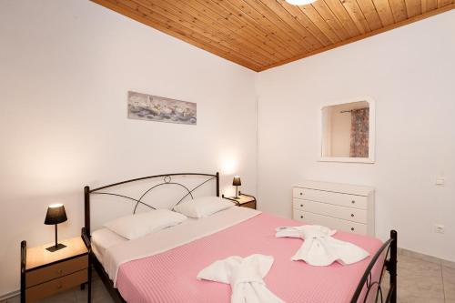 ポルト・ラフティにあるMTC-D Apartments by the Sea and Airportのベッドルーム1室(ピンクの毛布付きの大型ベッド1台付)