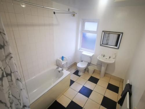 a bathroom with a tub and a toilet and a sink at City Place - Near Derby City Center in Derby