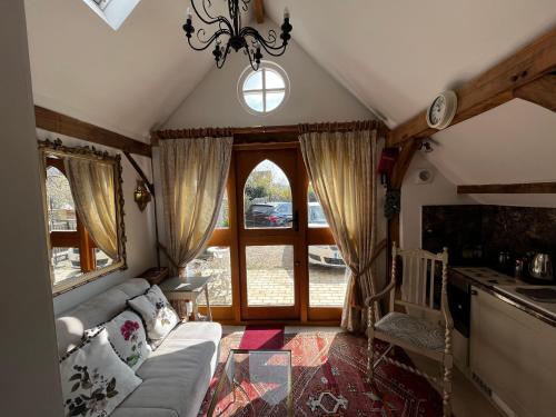 - un salon avec un canapé et une grande fenêtre dans l'établissement Remarkable 1-Bed Cottage near Henley-on-Thames, à Henley-on-Thames