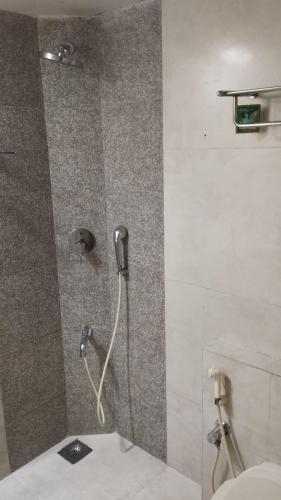 a shower in a bathroom with a toilet at SHARVARI BEACH HOME STAY at Mangalore by Vaishnavi Reveries in Mangalore