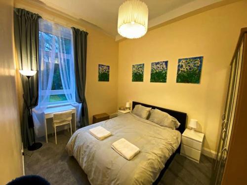 a bedroom with a bed with two towels on it at Paisley Pad: Glasgow Gateway in Paisley