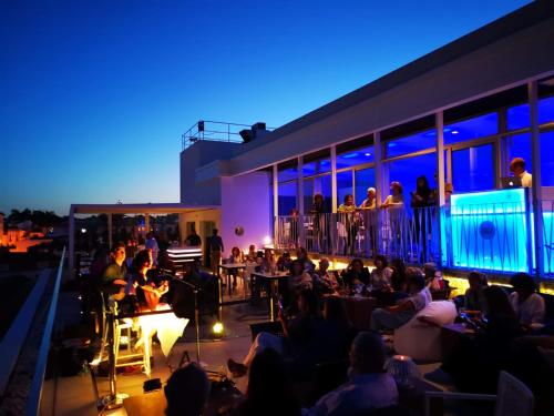 卡斯凱什的住宿－拜亞酒店，一群人晚上坐在阳台上
