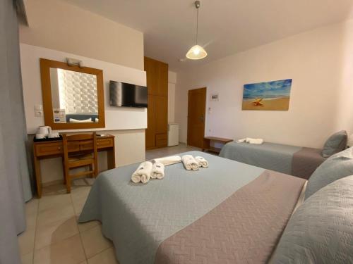 Pokój hotelowy z 2 łóżkami i biurkiem w obiekcie Castro Hotel w miejscowości Amoudara