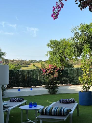 two tables with pillows sitting on top of a yard at La Alcaidesa Valerie & Bruno in San Roque