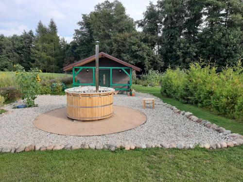 a wooden barrel in a garden with a gazebo at Odsapka u Agi in Wydminy