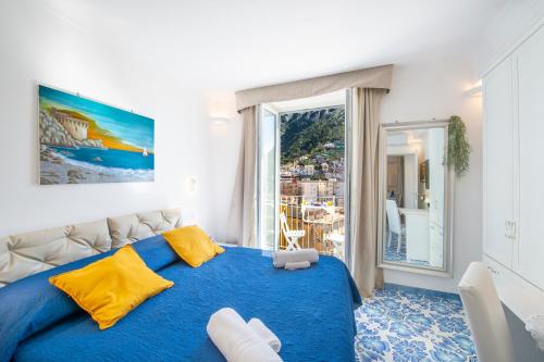 a bedroom with a blue bed and a large window at Casa Diodora, Costiera Amalfitana in Maiori
